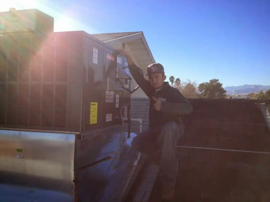 HVAC technician performing AC Tune-Up on a rooftop unit in Grand Island